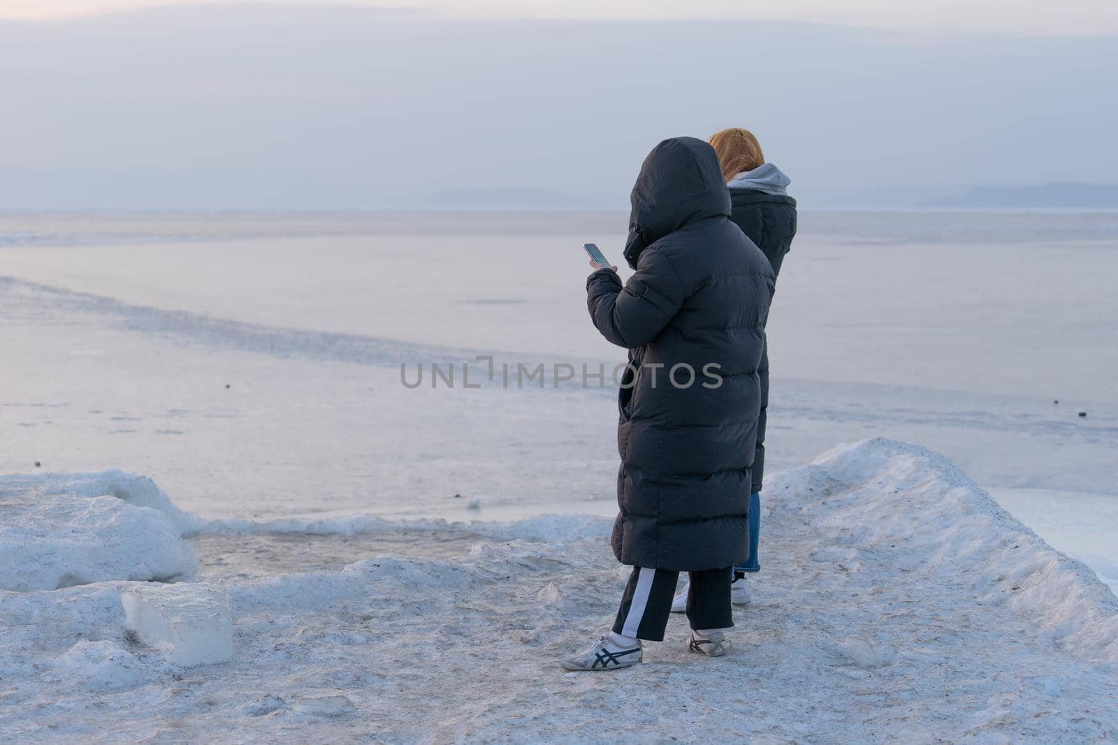 Vladivostok, Primorsky Krai. People in winter clothes standing on the icy surface of the sea.