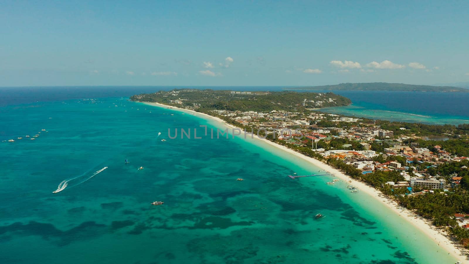 Tropical lagoon with turquoise water and white sand beach from above. Boracay, Philippines. White beach with tourists and hotels. Summer and travel vacation concept.