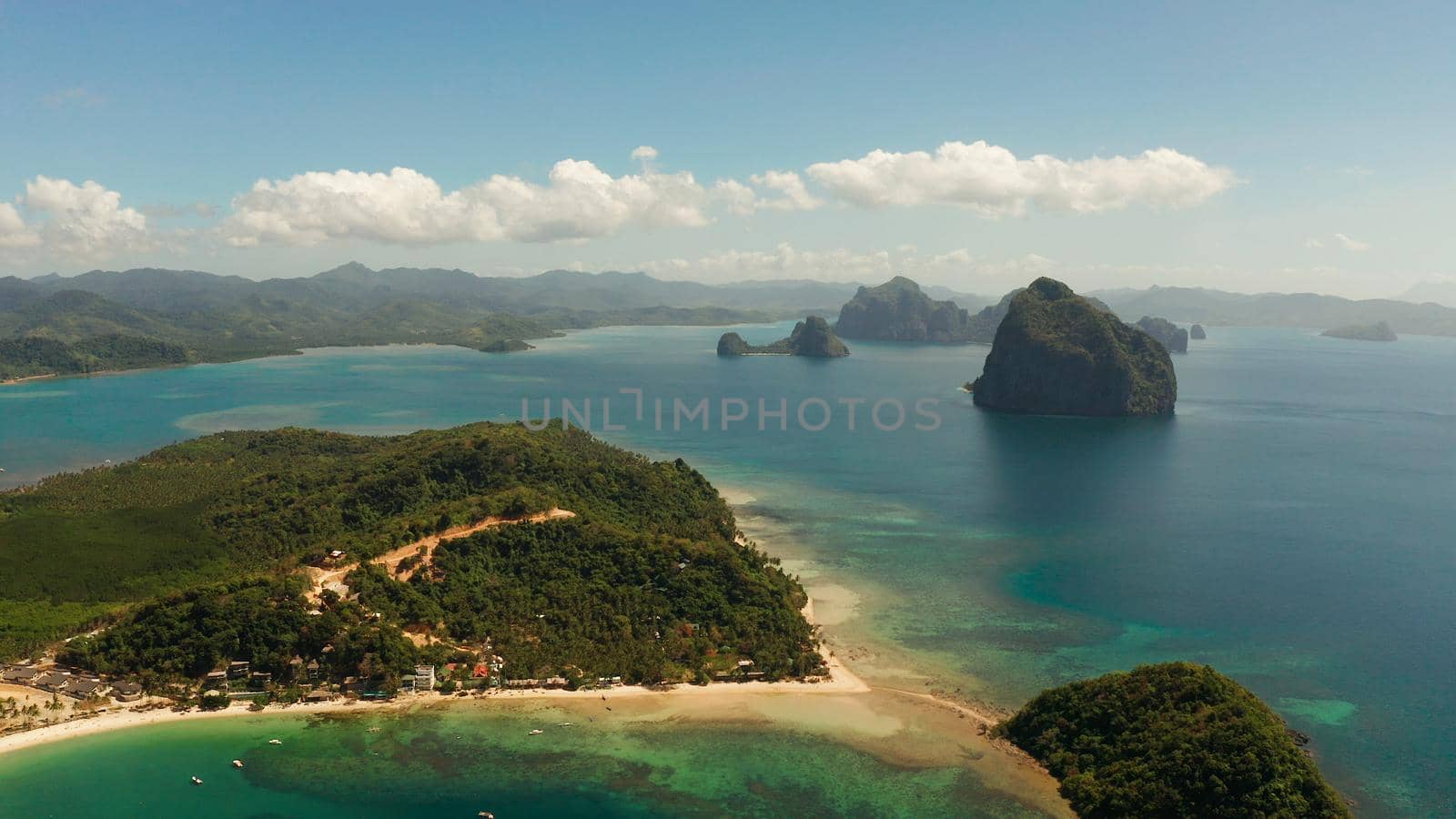 Tropical sandy beach and blue water, aerial view. Las Cabanas, El Nido, Palawan, Philippines. Seascape with sea, sand, palm trees. Summer and travel vacation concept