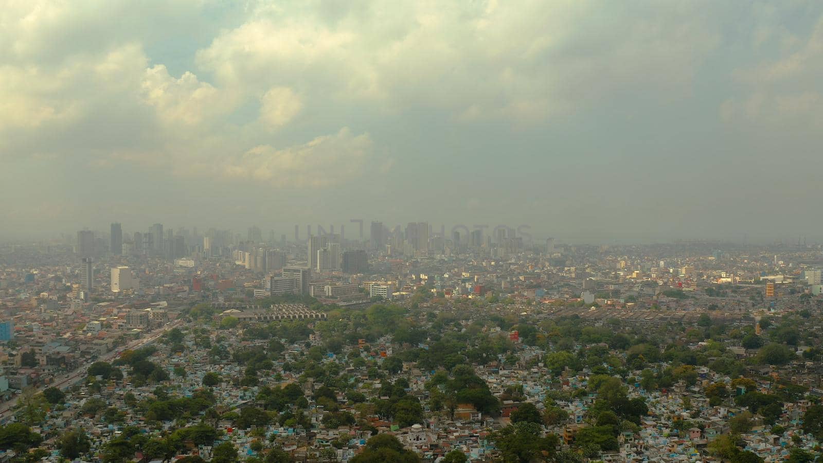 Manila North Cemetery on the background of skyscrapers and modern buildings, aerial drone. Travel vacation concept