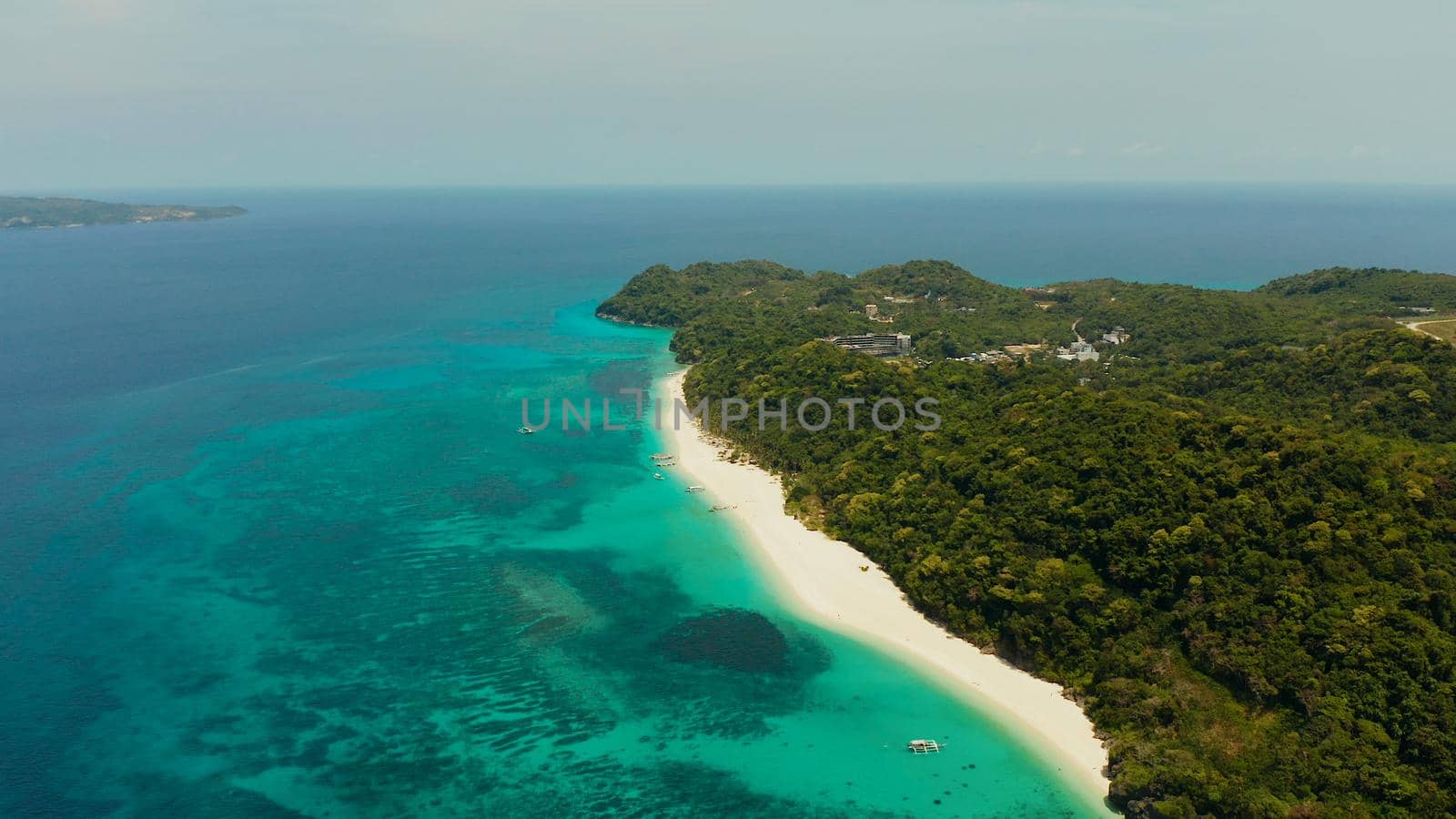 Sandy beach and turquoise water in the tropical resort of Boracay, Puka shell beach, Philippines aerial view. White beach with tourists. Summer and travel vacation concept.