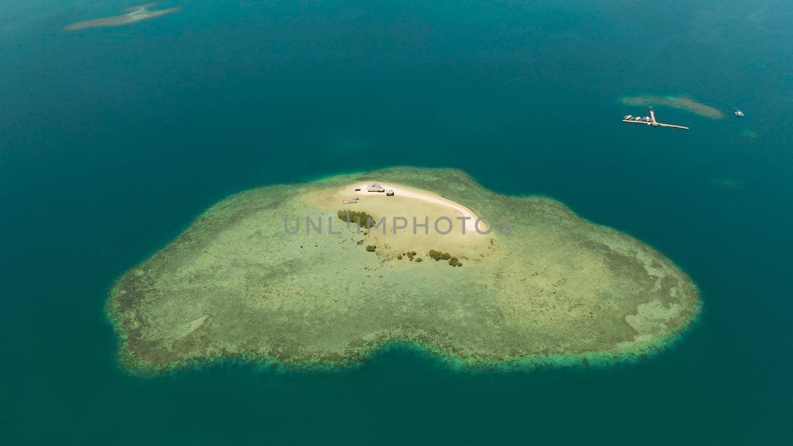 Sandy island with sand bar surrounded by coral reef and blue sea in honda bay, aerial view. Coral atoll with a sandy beach. Summer and travel vacation concept, Philippines, Palawan