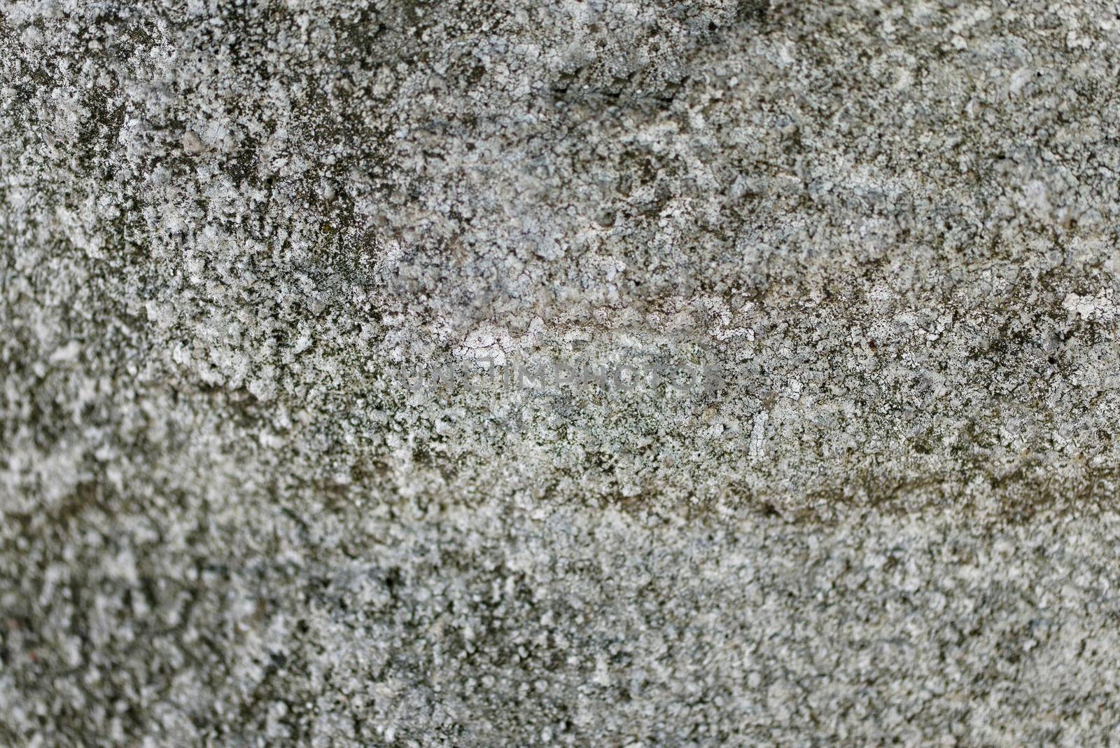 Close-up of a solid wall of rough gray cement with uneven depressions.Texture or background