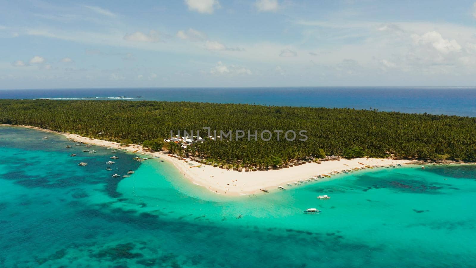 Seascape with beautiful beach and tropical island palm trees by coral reef from above. Daco island, Philippines. Summer and travel vacation concept