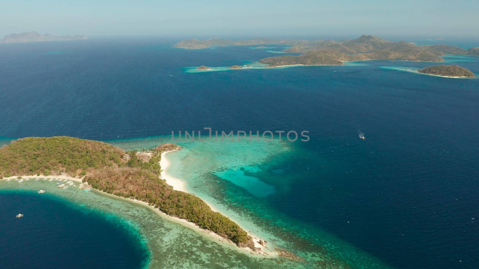 aerial view tropical islands with blue lagoons, coral reef and sandy beach. Palawan, Philippines. Islands of the Malayan archipelago with turquoise lagoons.
