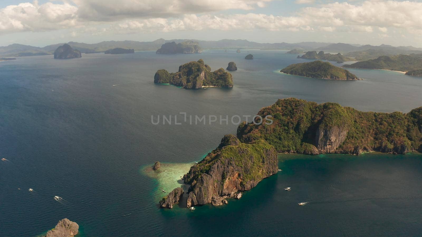 Cove with lagoons and the tropical islands, aerial view. Seascape with tropical rocky islands, ocean blue water. islands and mountains covered with tropical forest. El nido, Philippines, Palawan. Tropical Mountain Range