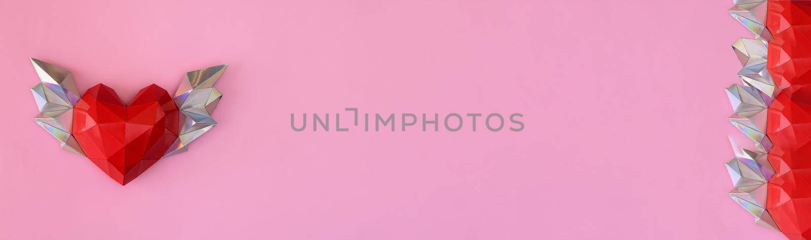Banner. A heart with wings. Greeting card for Valentine's Day, weddings. On a pink background. Polygon shape. copy space