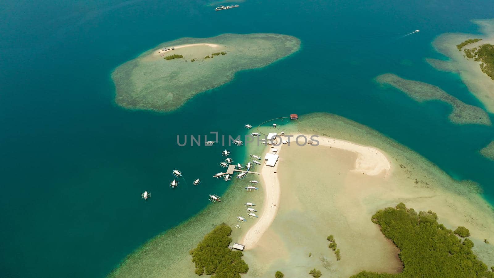 Beautiful beach on tropical island surrounded by coral reef, sandy bar with tourists. honda bay top view. Luli island. Summer and travel vacation concept, Philippines, Palawan