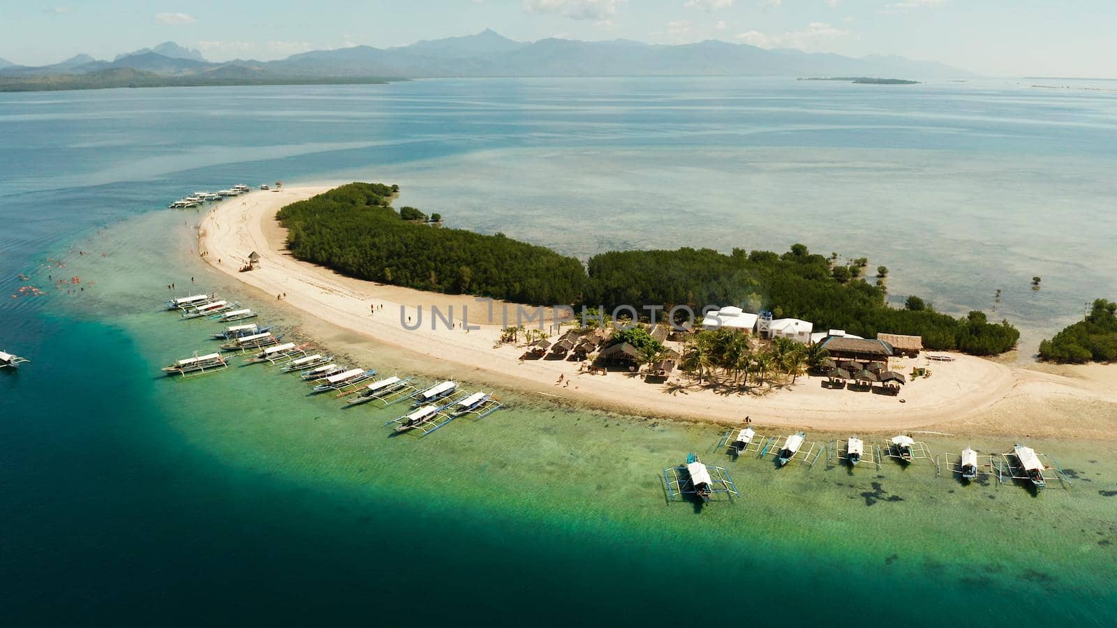 Beautiful beach on tropical island surrounded by coral reef, sandy bar with tourists. honda bay top view. Starfish island. Summer and travel vacation concept, Philippines, Palawan