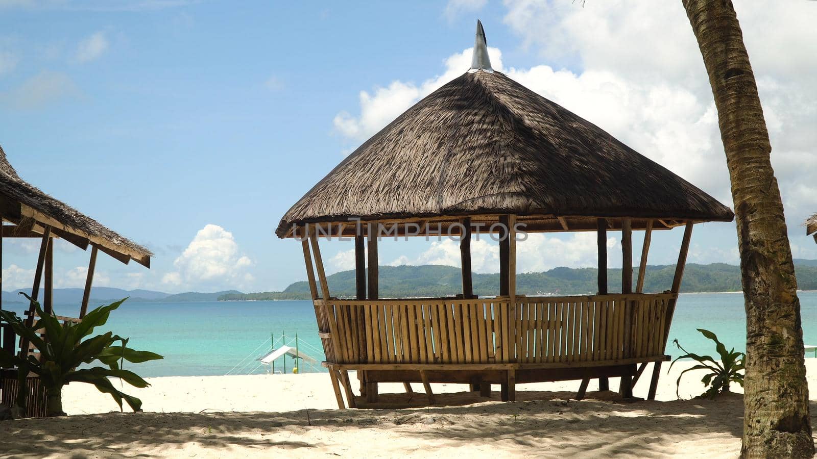 Beach with white sand with beach house on a tropical island Daco. Beautiful sky, sea, resort. Seascape: Ocean and beautiful beach paradise. Philippines. Travel concept.