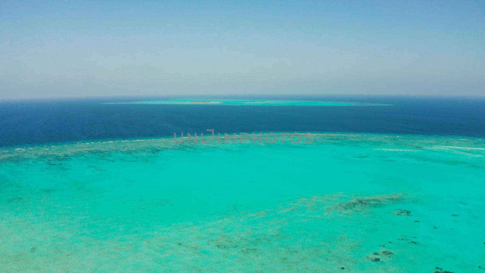 Tropical coral atoll with turquoise water against the sky with clouds top view. Summer and travel vacation concept. Balabac, Palawan, Philippines