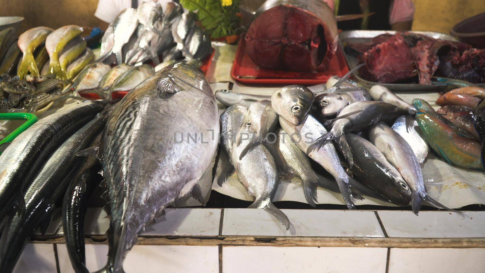 Fresh fish in Asian market. Sale of fresh sea fish in the Asian public store. Sea fish lying on the shopboard at one of the street markets. Philippines.