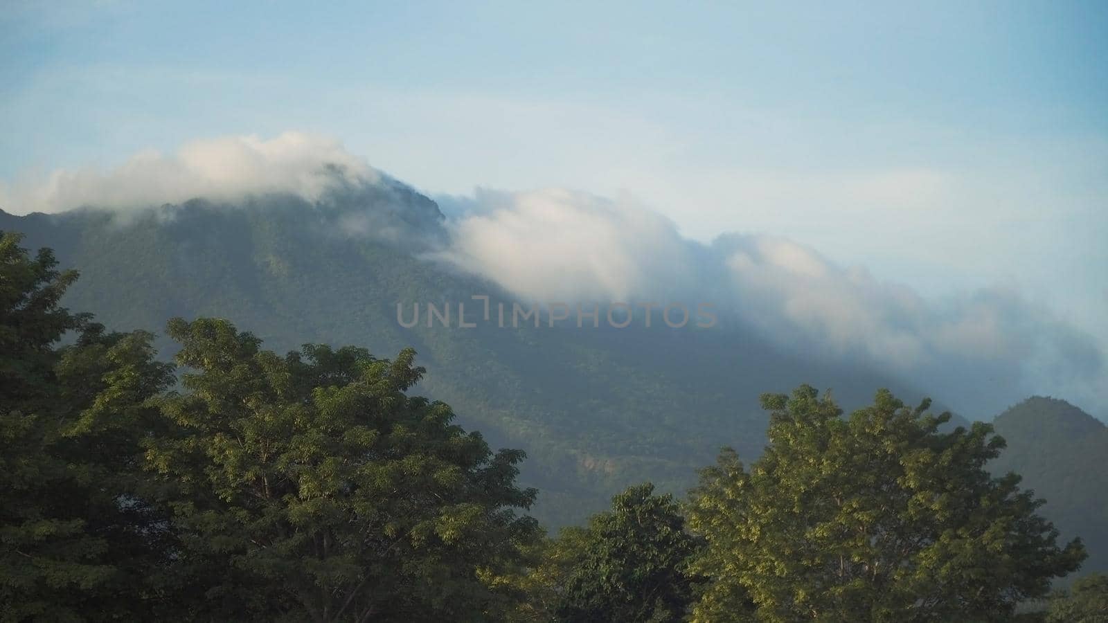 Mountains landscape, rainforest, jungle, blue sky, clouds and mist. Volcano on the island of Camiguin. Travel concept.