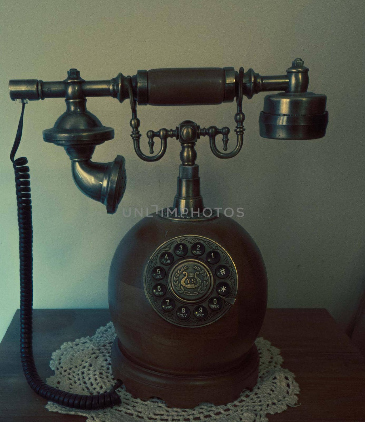 Antique fixed telephone with earphone and made of wood by xavier_photo
