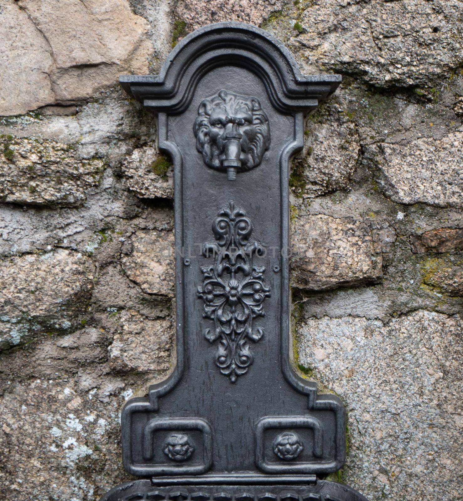 Antique wrought iron fountain on stone background