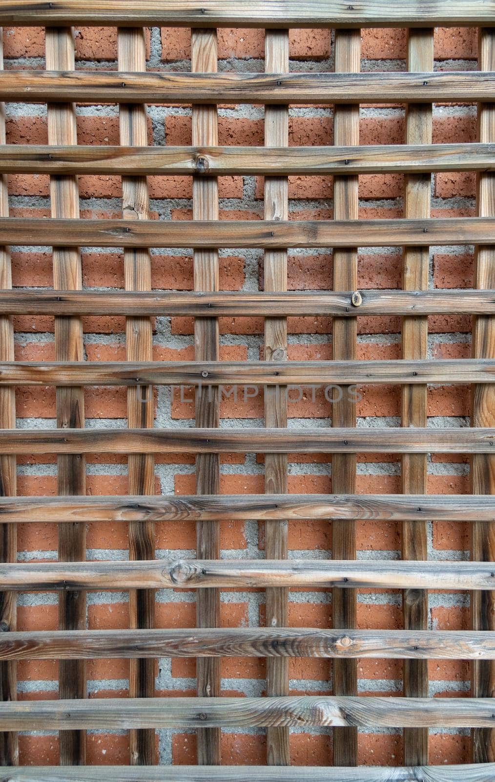 Antique wooden grille with red brick backdrop