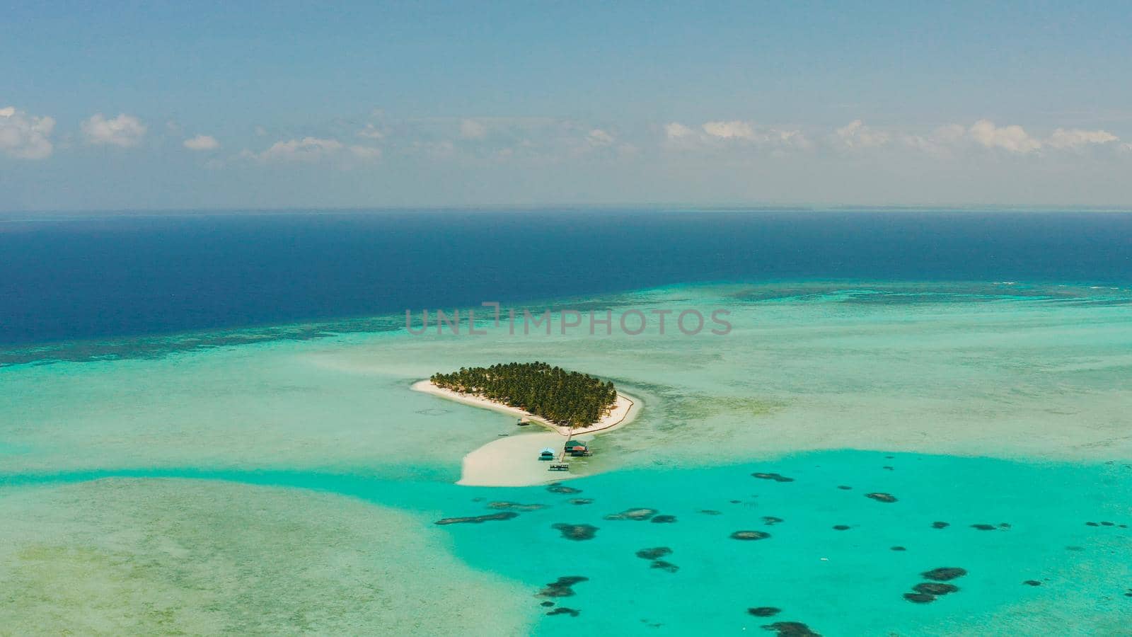 Tropical landscape: small island with beautiful beach, palm trees by turquoise water view from above. Onok Island, Balabac, Philippines. Summer and travel vacation concept