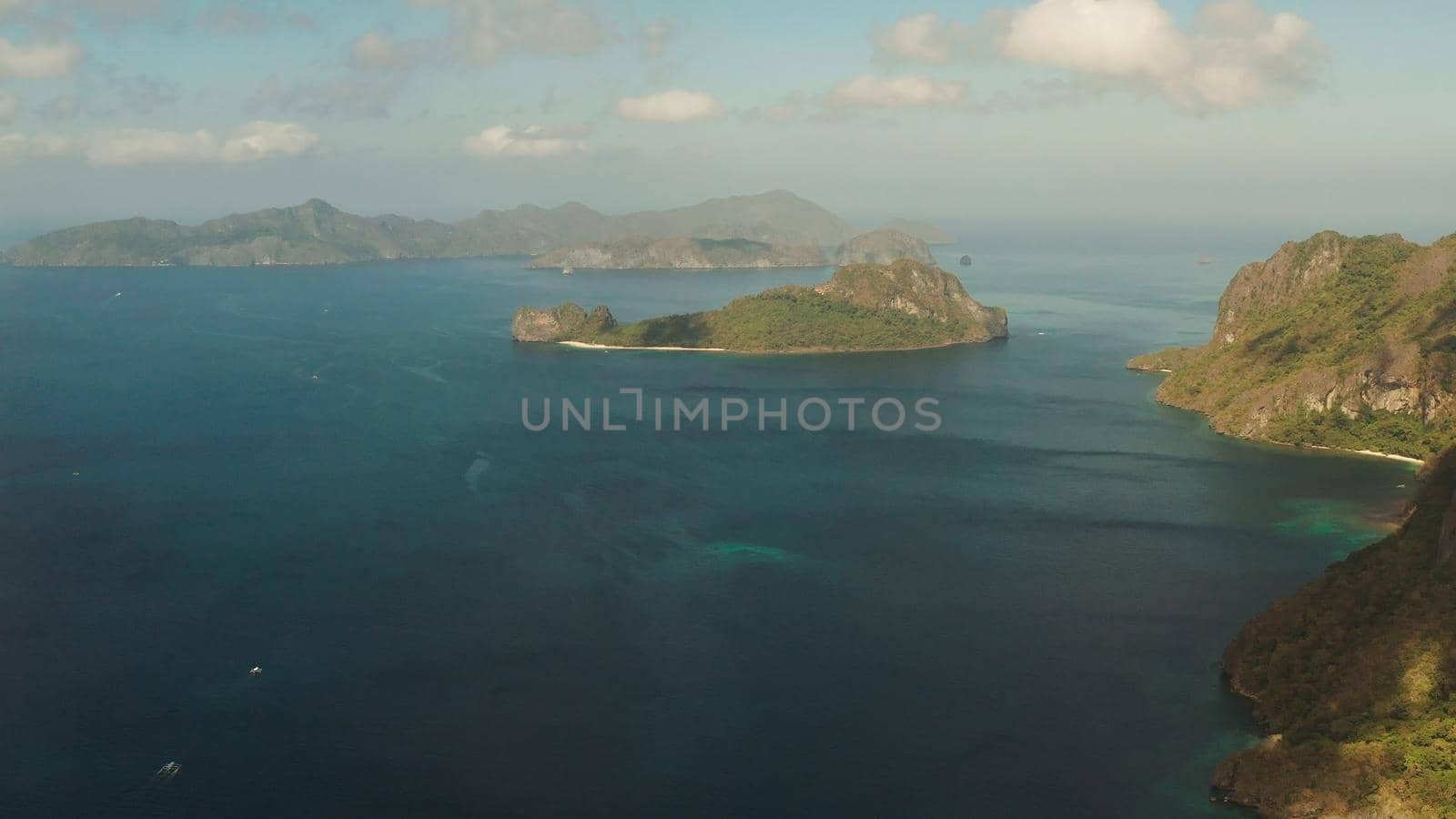 Seascape with tropical bay, rocky islands, ocean blue water, aerial view. islands and mountains covered with tropical forest. El nido, Philippines, Palawan. Tropical Mountain Range