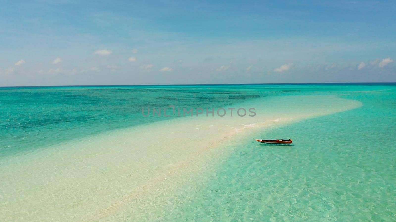 Sandy beach with tourists among turquoise waters and coral reefs. Mansalangan sandbar. Beach at the atoll. Summer and travel vacation concept. Balabac, Palawan, Philippines.