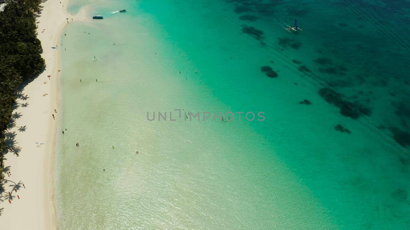 Tropical white sand beach, hotels near the blue lagoon and corall reef. aerial view, Boracay, Philippines. Seascape with beach on tropical island. Summer and travel vacation concept.