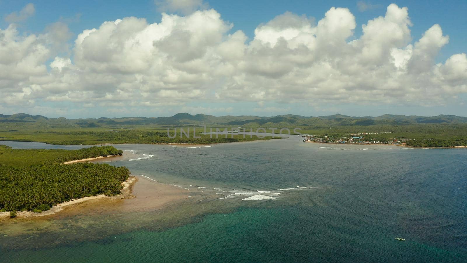 City in wetlands and mangroves on the ocean coastline aerial view. Siargao island, Philippines.