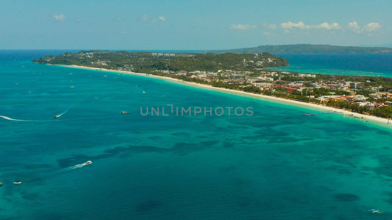 Tropical white beach with tourists and hotels near the blue sea, aerial view. Summer and travel vacation concept.