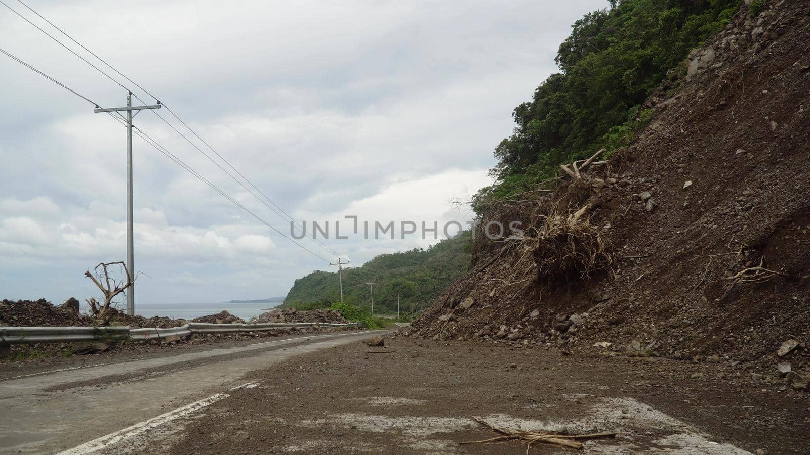 Landslides and rockfalls on the road in the mountains. Mud and rocks blocking the road.Destroyed rural road landslide damaged in powerful flood. Collapsed on the mountain. Philippines, Camiguin.