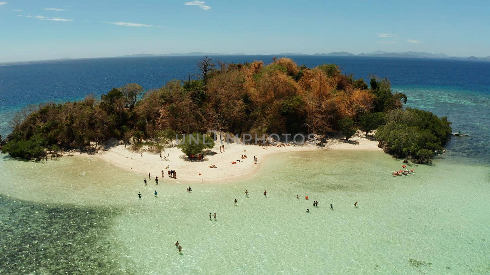 aerial seascape tourists enjoy tropical beach. tropical island with sand beach CYC, palm trees. Philippines, Palawan. Tropical landscape with blue lagoon, coral reef