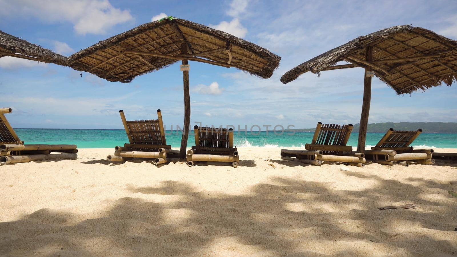 Beach with deck chairs, sun beds, umbrellas.Beach, sea, sand,wave. Seascape ocean and beautiful beach paradise, blue sky, clouds. Philippines Travel concept