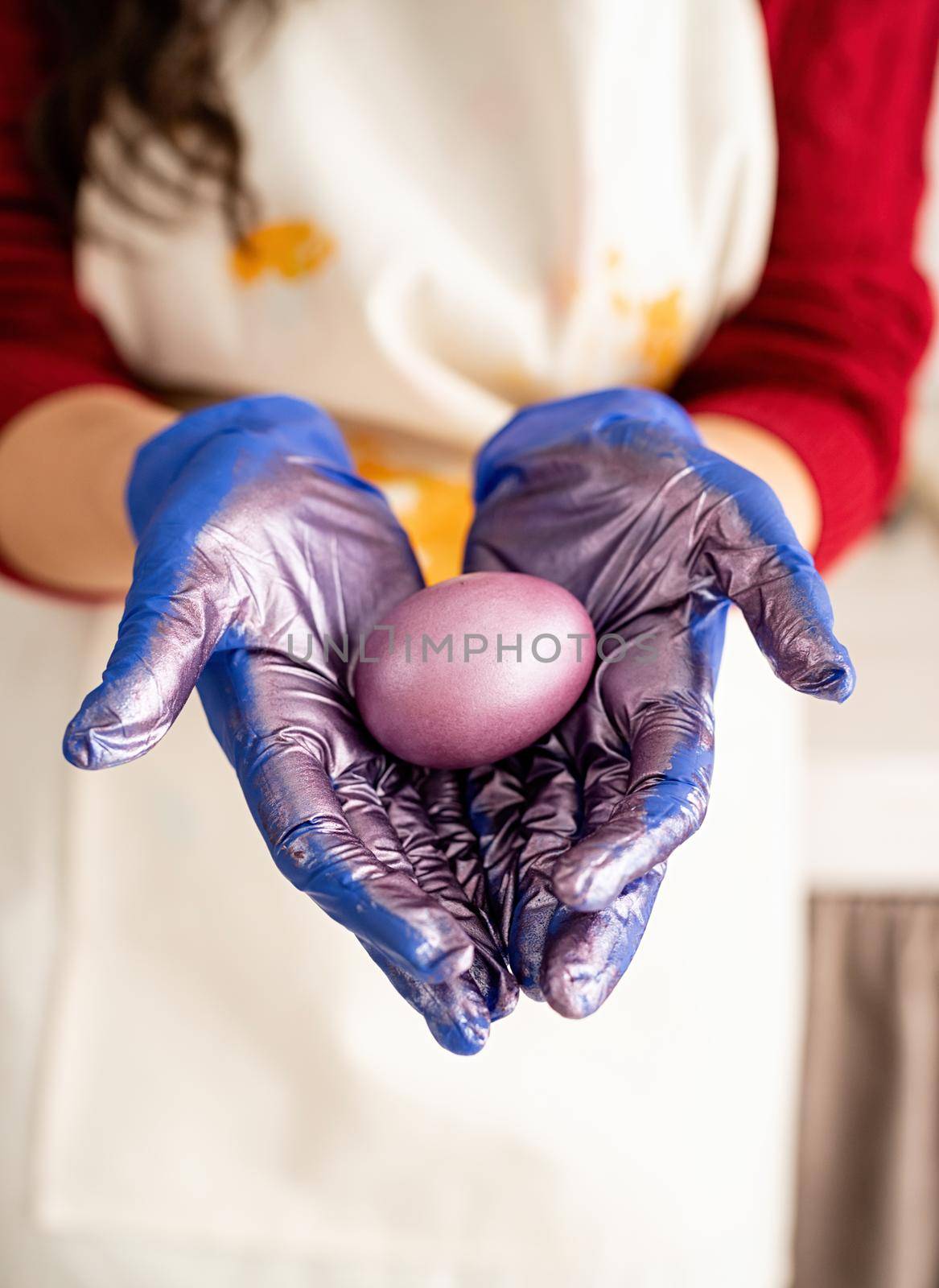 Woman hands holding purple colored easter egg