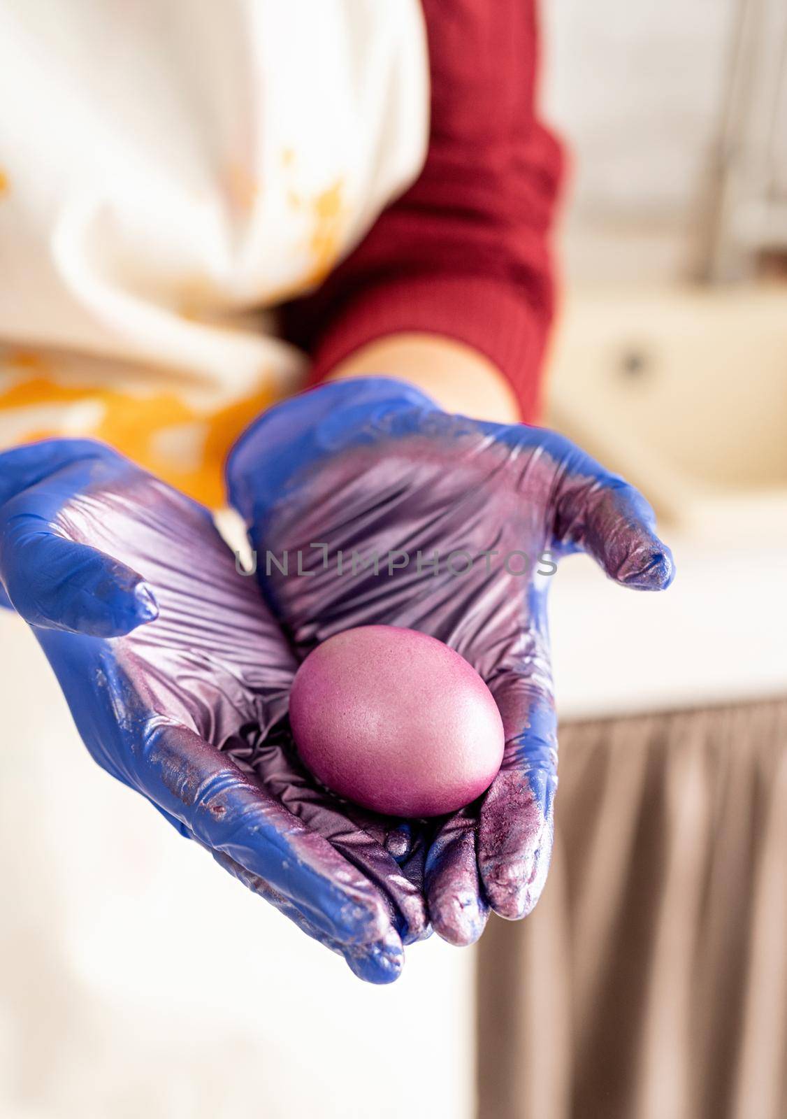 Woman hands holding purple colored easter egg