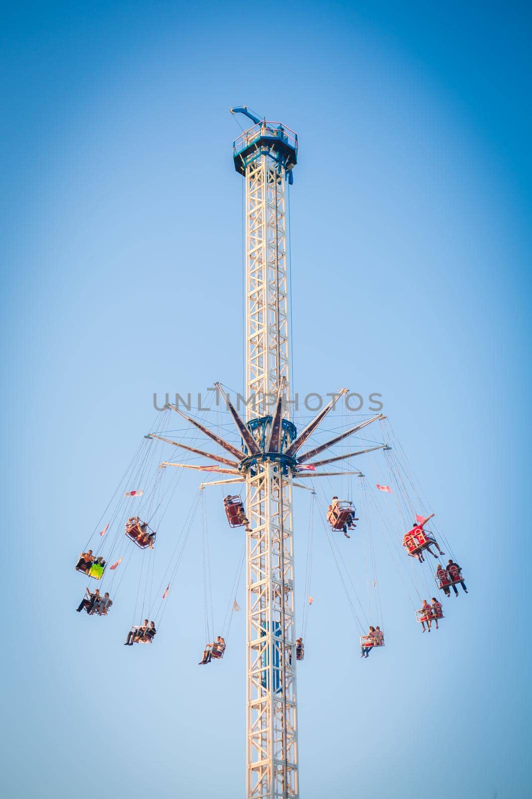 People have fun enjoying the air carousel in the amusement park.