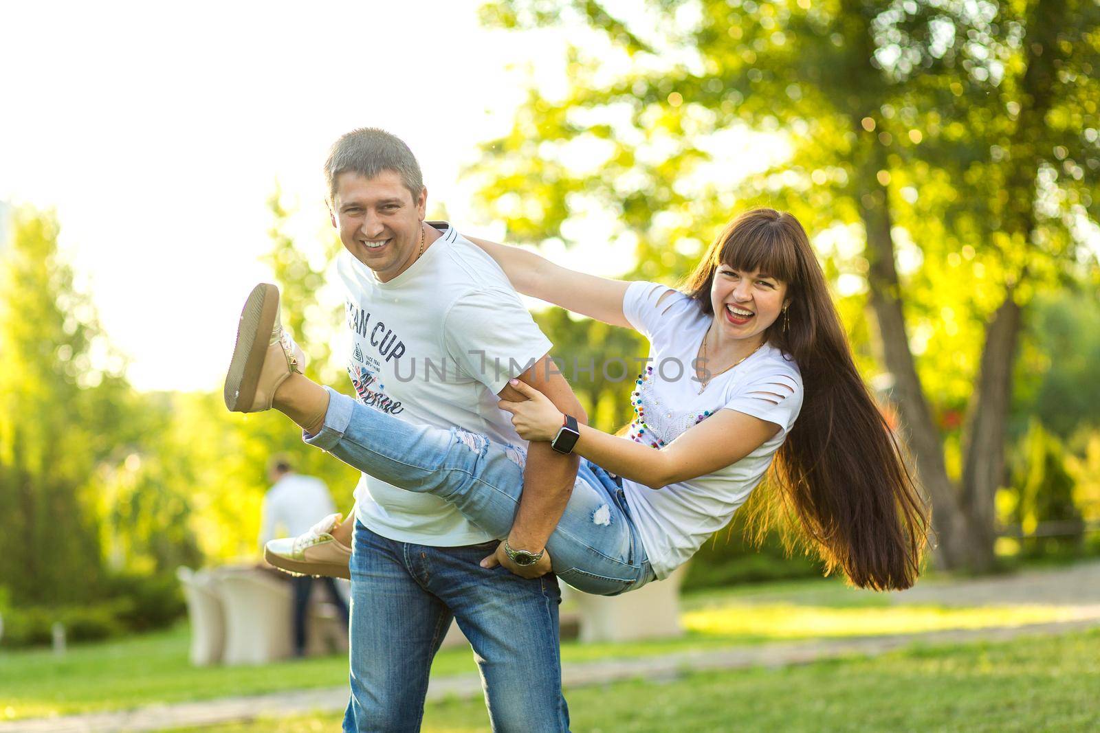 Young romantic couple have fun enjoy each other in green summer park.