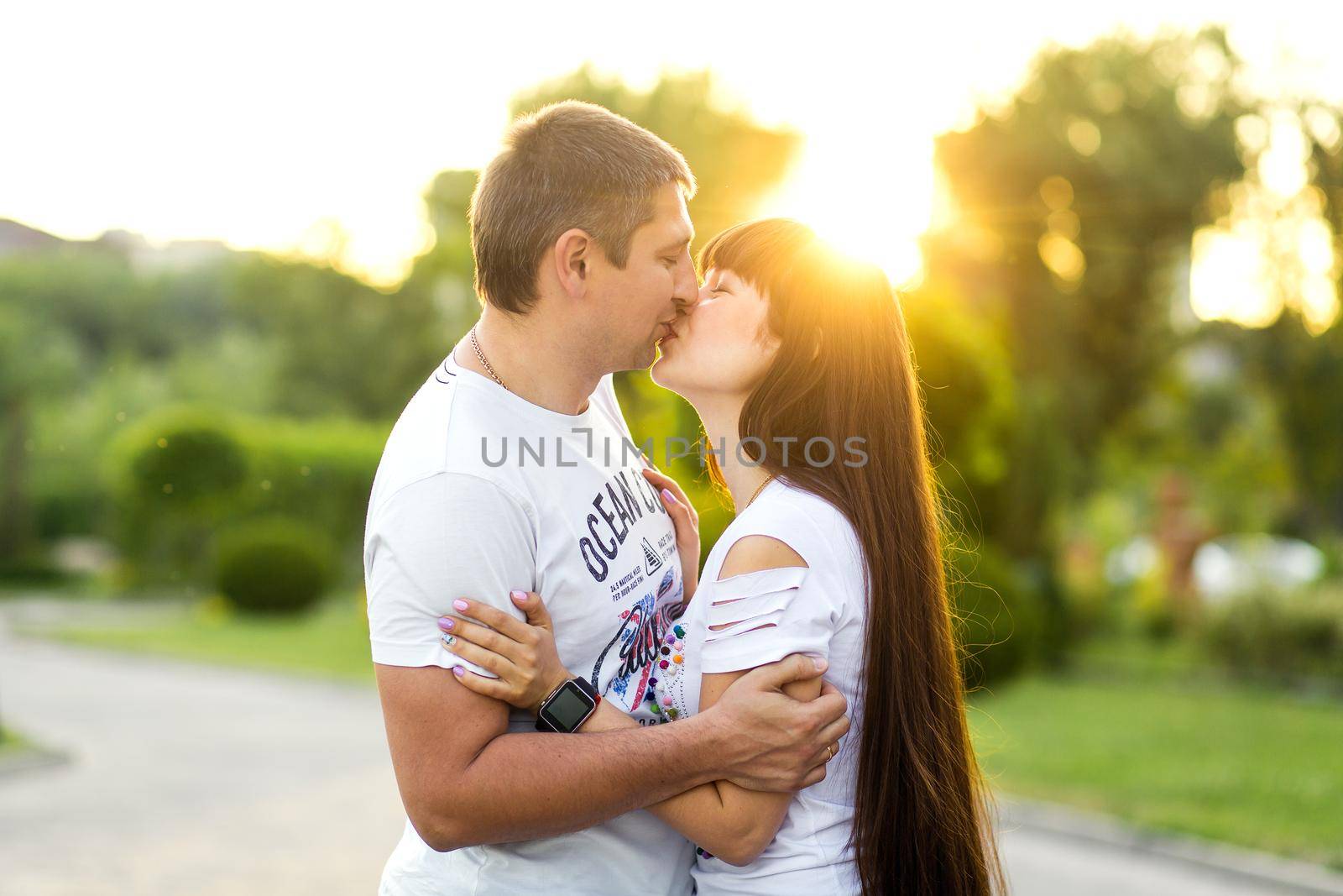 Young romantic couple have fun enjoy each other in green summer park.