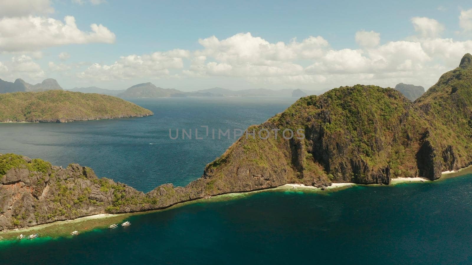 Bay and the tropical islands. Seascape with tropical rocky islands, ocean blue wate, aerial view. islands and mountains covered with tropical forest. El nido, Philippines, Palawan. Tropical Mountain Range