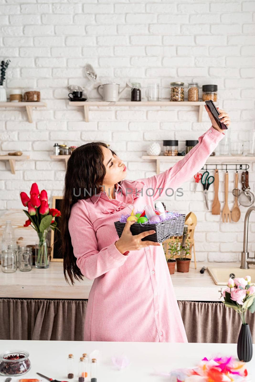 Beautiful brunette woman taking selfie using mobile phone in the kitchen