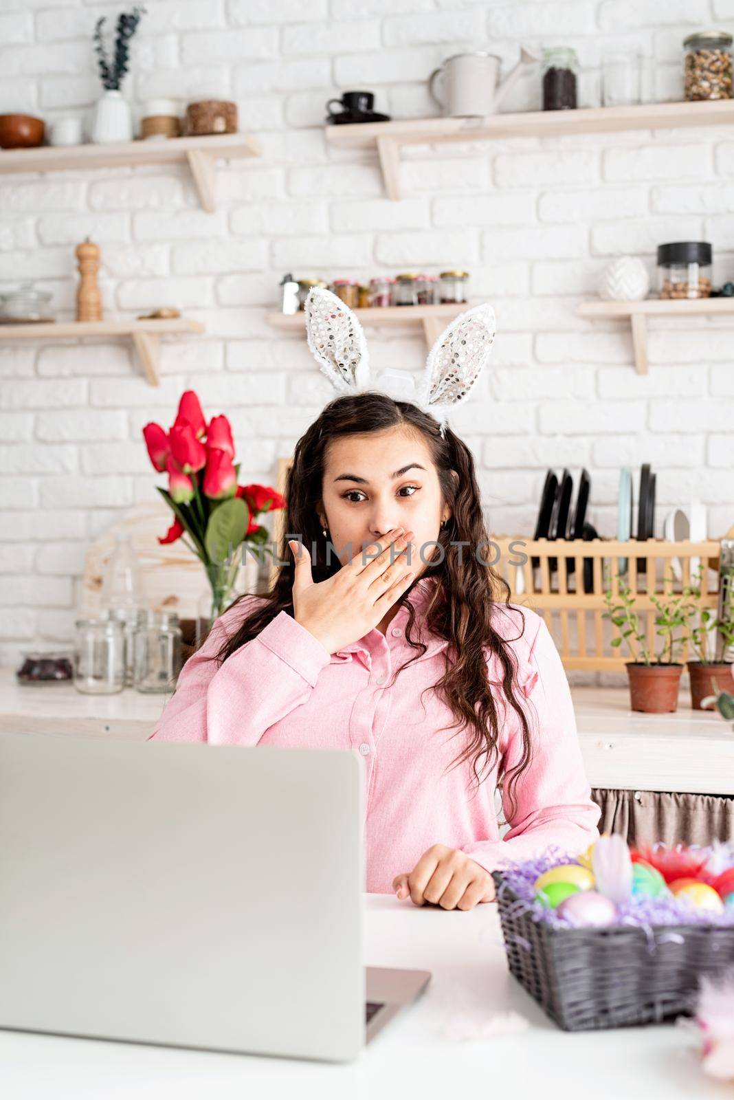 Funny surprised woman in rabbit ears greeting her friends online, celebrating easter