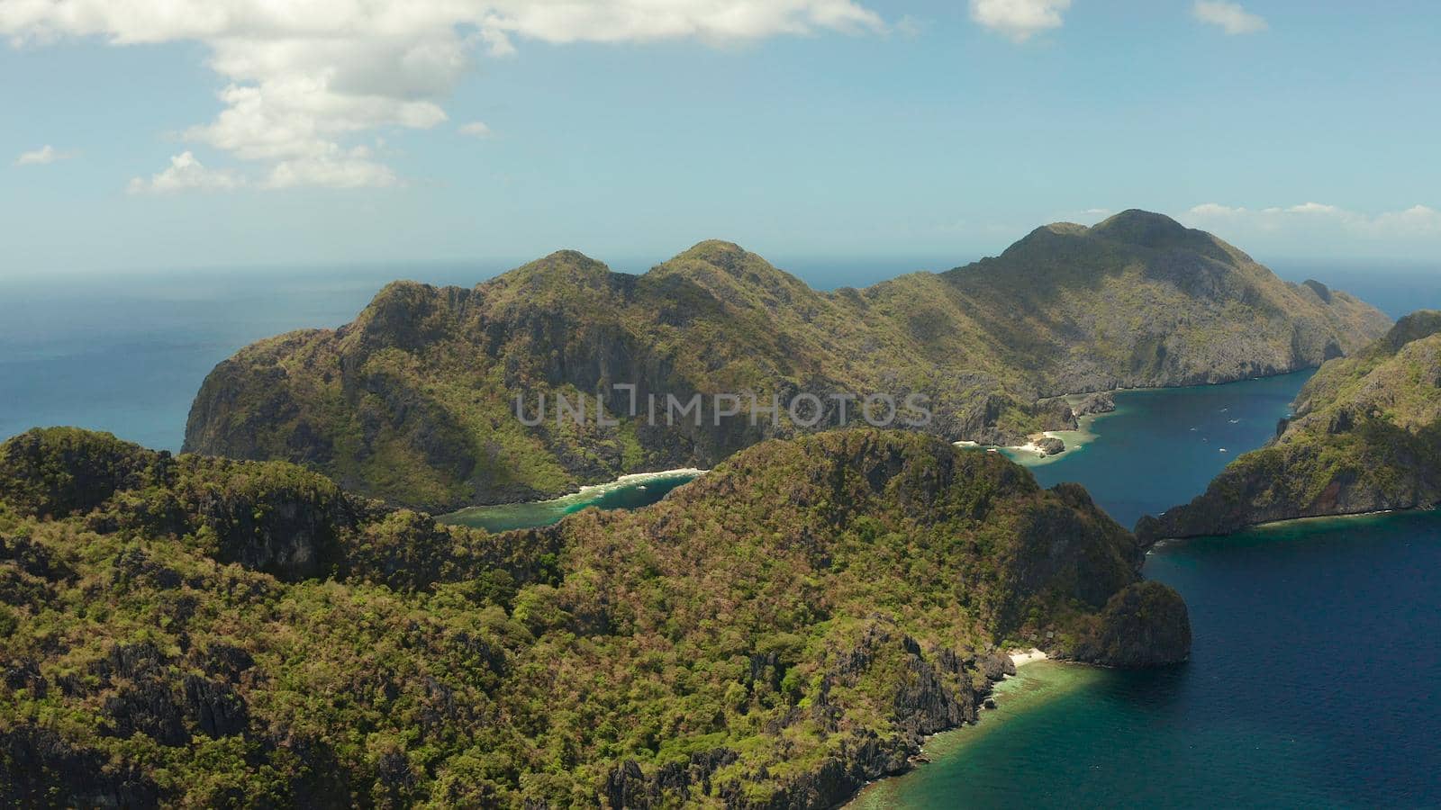 Seascape with tropical rocky islands, ocean blue water, aerial view . islands and mountains covered with tropical forest. El nido, Philippines, Palawan. Tropical Mountain Range