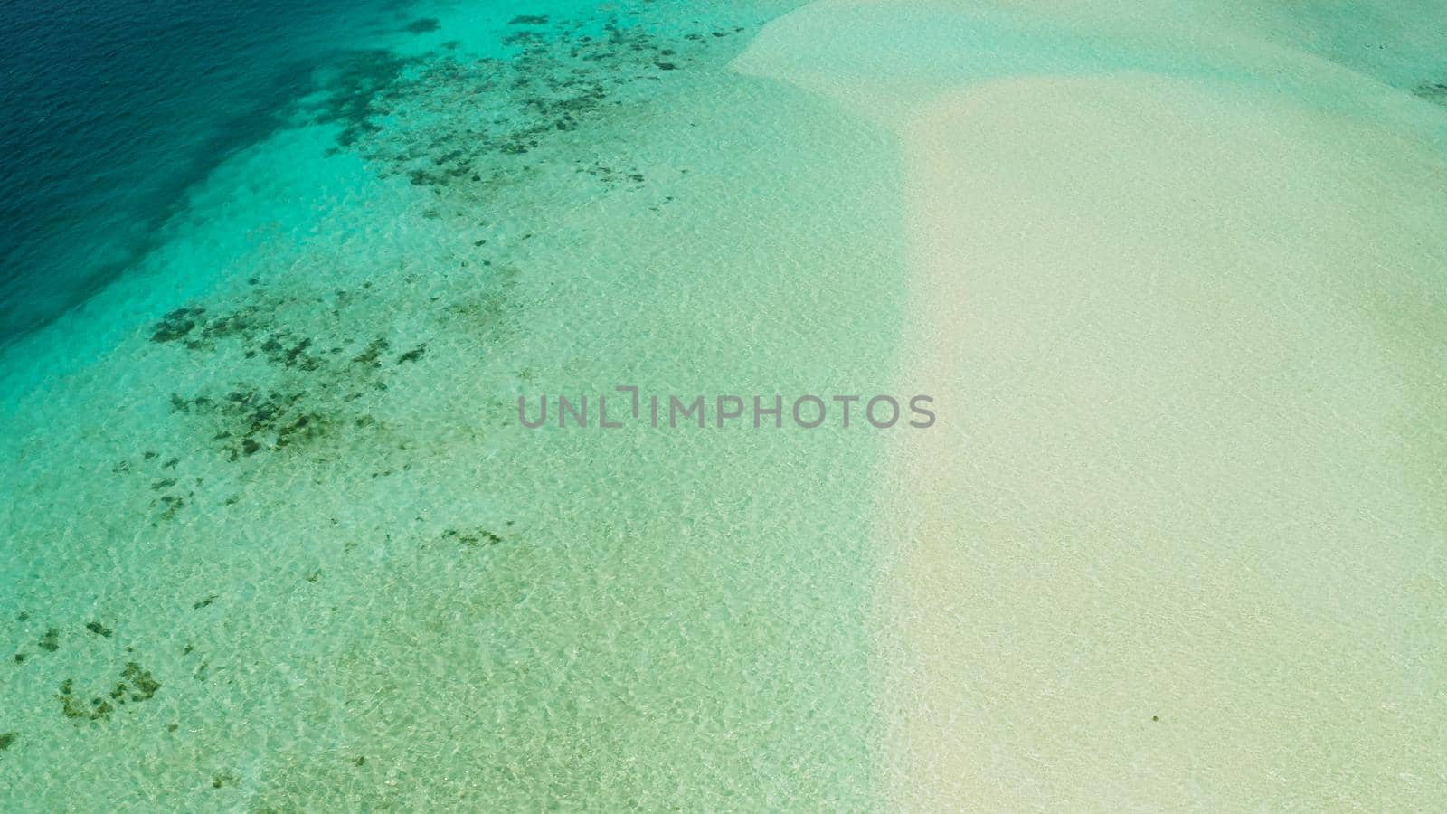 White sandy beach in the lagoon with turquoise water on a tropical island. Mansalangan sandbar. Beach at the atoll. Summer and travel vacation concept. Balabac, Palawan, Philippines.