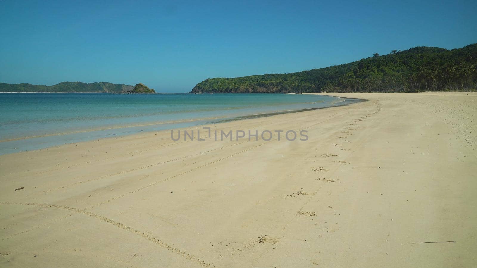 Tropical beach and blue sea with waves. Nacpan, El Nido, Palawan, Philippines. Seascape with sea, sand, palm trees. Summer and travel vacation concept