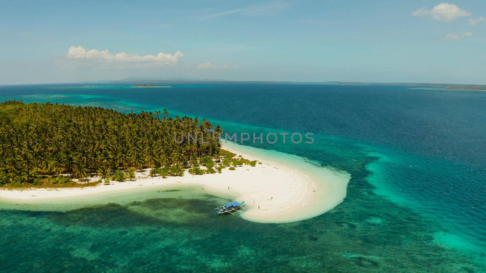 Tropical island with sandy beach by atoll with coral reef and blue sea, aerial view. Patongong Island with sandy beach. Summer and travel vacation concept.