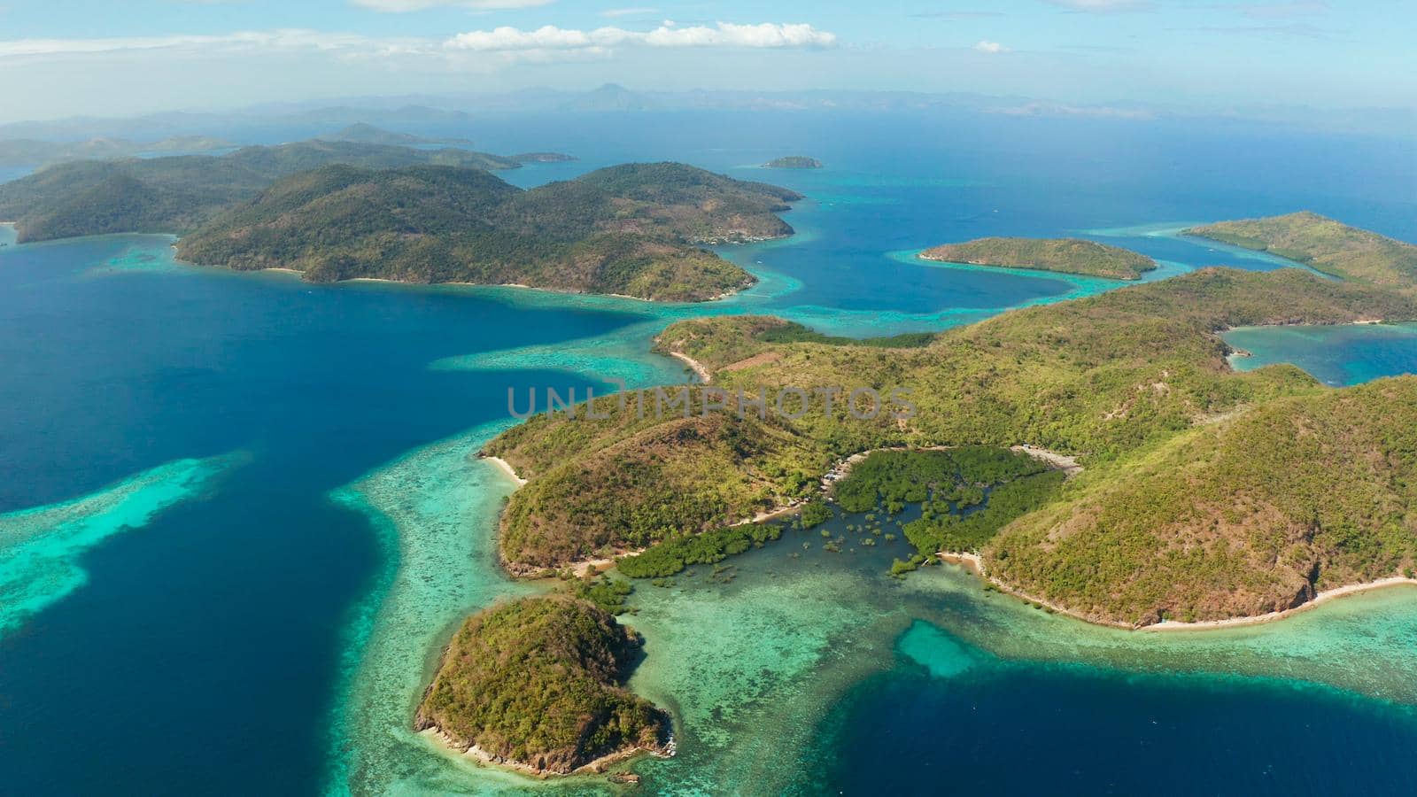 aerial view tropical islands with blue lagoons, coral reef and sandy beach. Palawan, Philippines. Islands of the Malayan archipelago with turquoise lagoons.