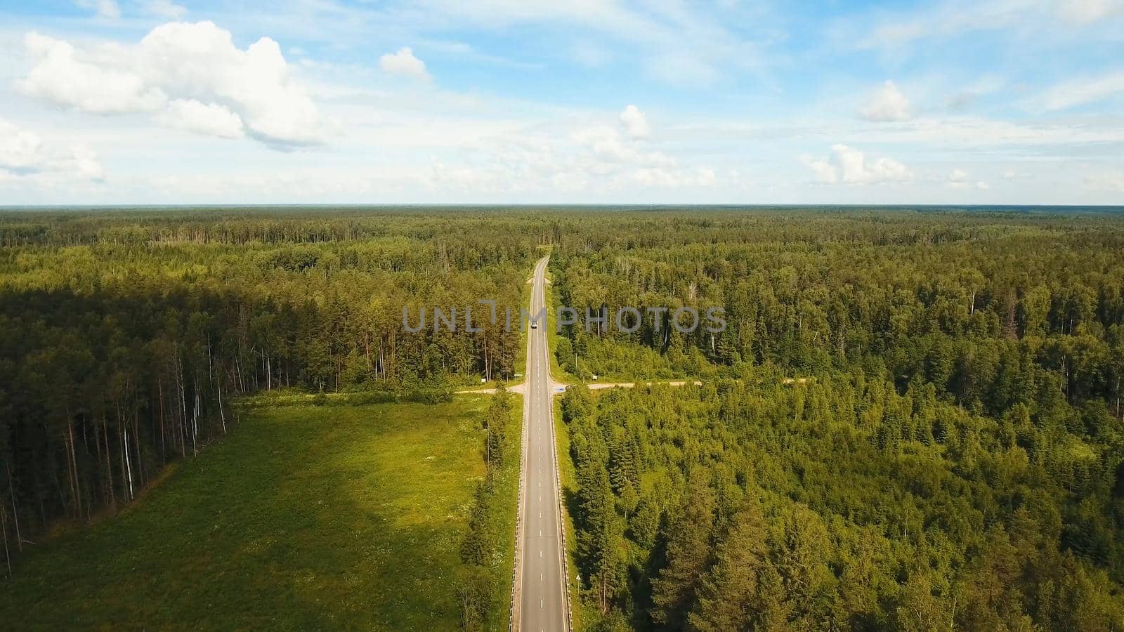 Highway among the green woods in the countryside. Aerial view Road through the green forest.