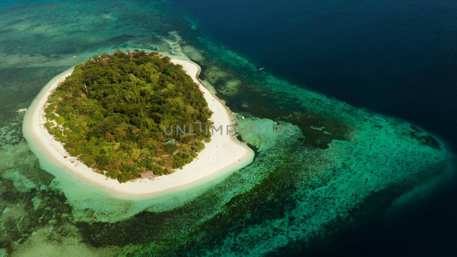 Tropical island and sandy beach surrounded by atoll and coral reef with turquoise water, aerial drone. Tropical island and coral reef. Summer and travel vacation concept, Camiguin, Philippines, Mindanao