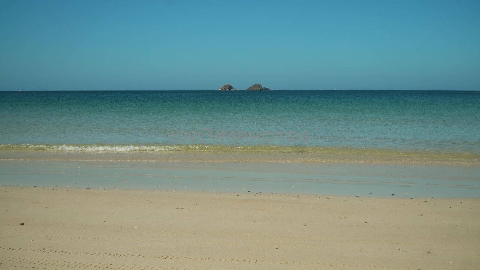 Wide sandy beach and palm trees by the sea. Nacpan, El Nido, Palawan, Philippines. Summer and travel vacation concept