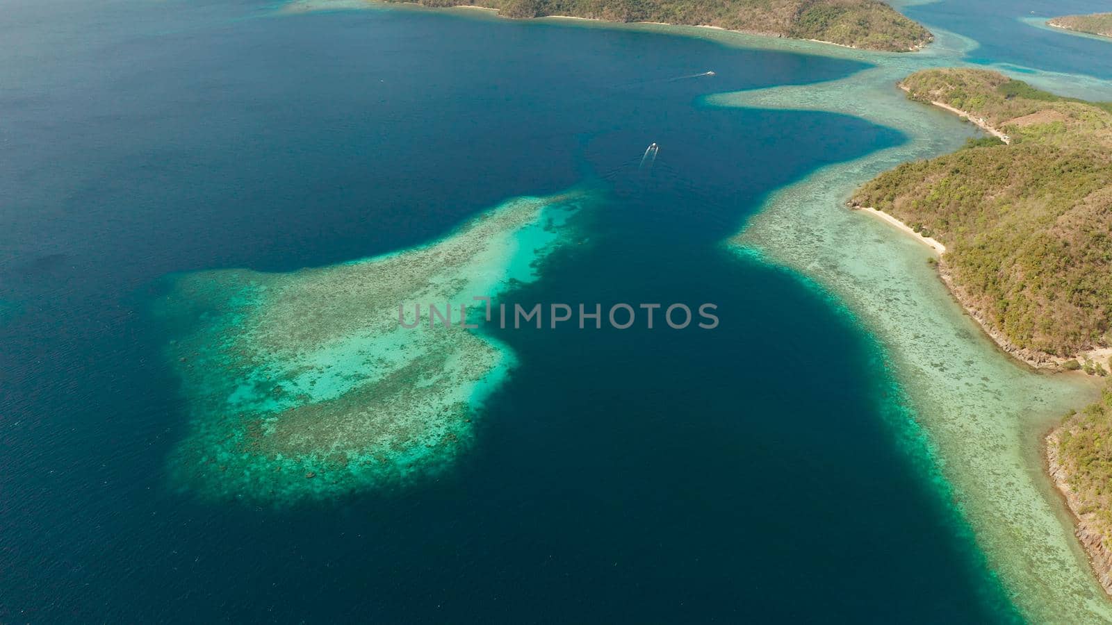 aerial view tropical islands with blue lagoon, coral reef and sandy beach. Palawan, Philippines. Islands of the Malayan archipelago with turquoise lagoons.