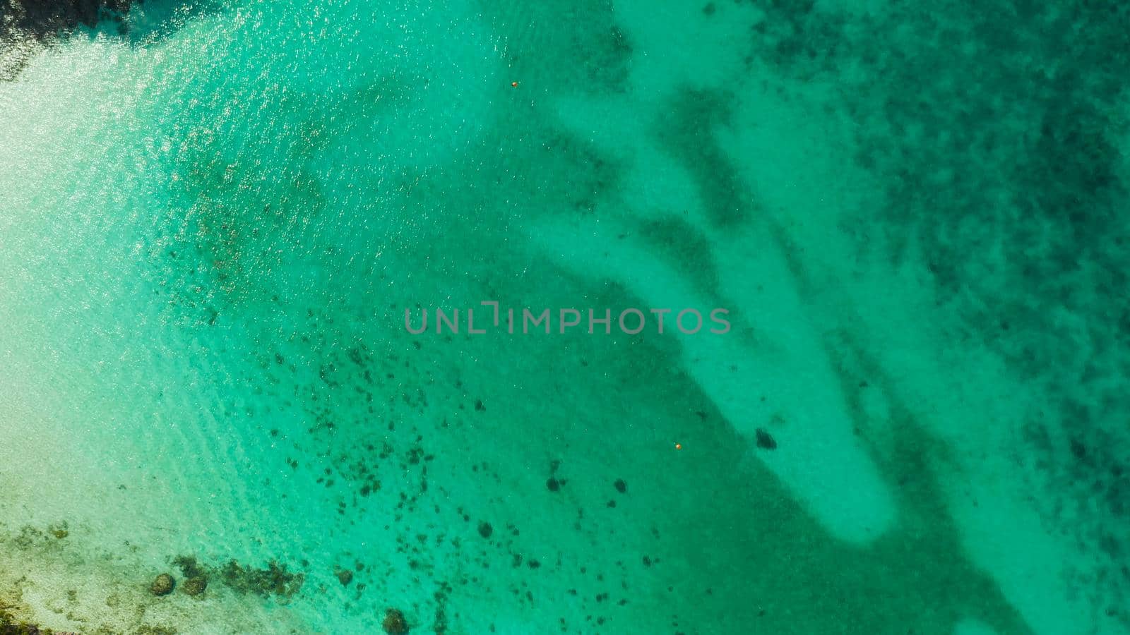 Sea water surface in lagoon, background with sun light reflection, copy space for text, aerial view. Top view transparent turquoise ocean water surface. background texture