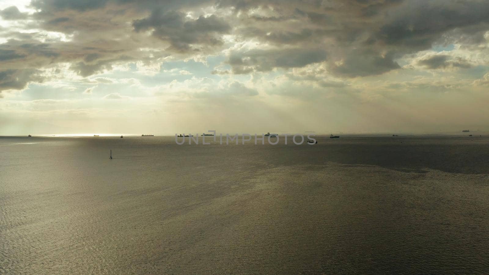 Colorful bright clouds during sunset over Manila bay with ships, aerial view. Sunset over ocean. Seascape, Summer and travel vacation concept.