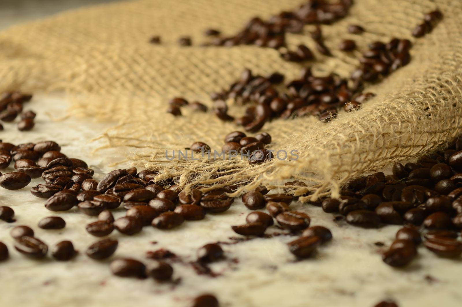 A burst open burlap with coffee beans spilling into the scene.