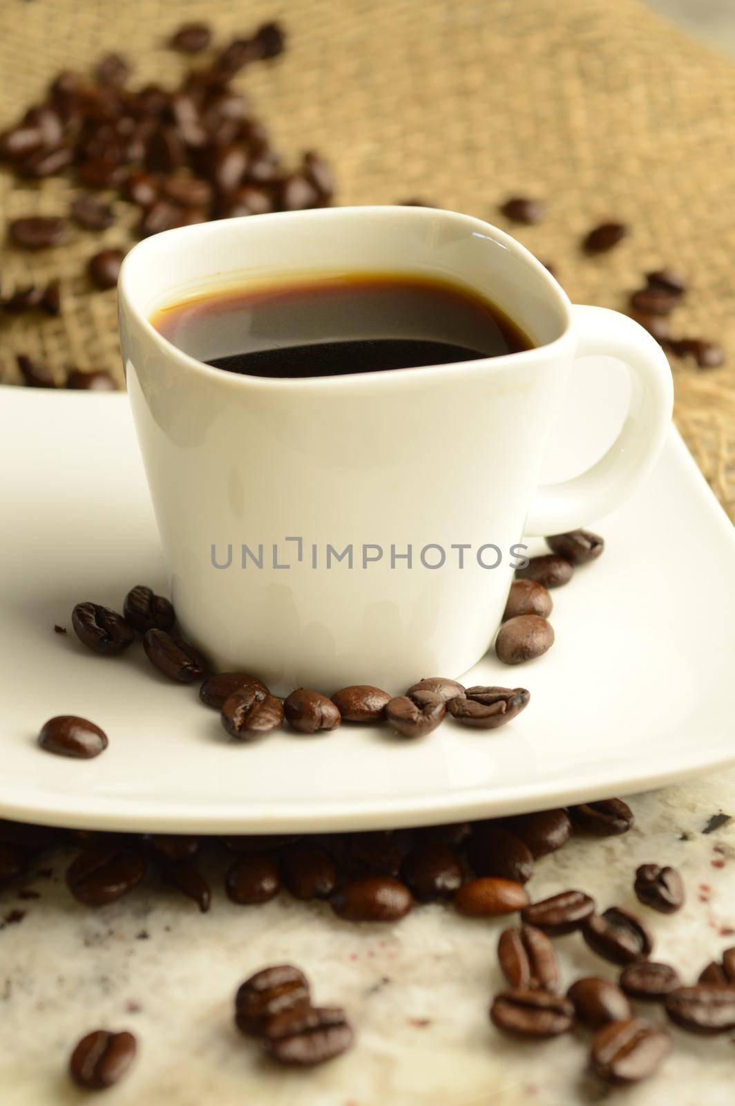 A single cup of espresso in an aromatic roasted coffee bean scene.
